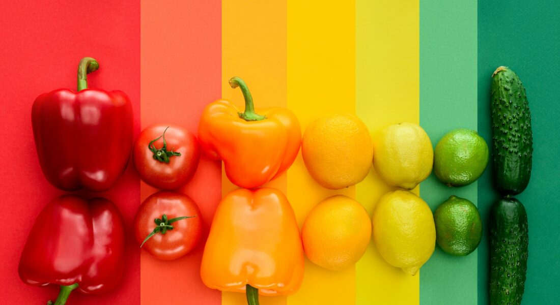 top view of ripe fruits and vegetables on rainbow surface