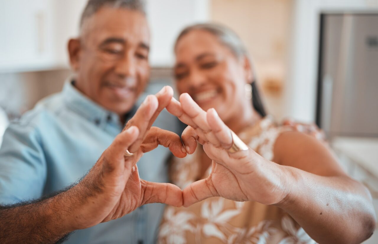 Hands, heart and love with a senior couple in their retirement home together for health, wellness a