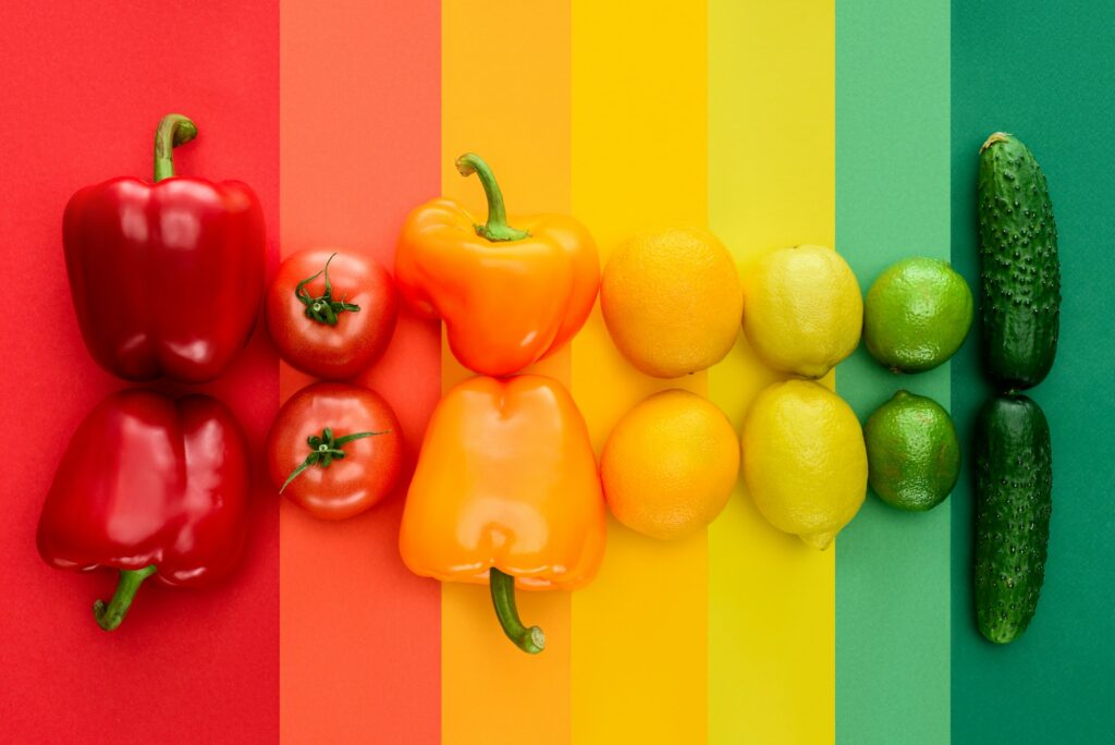 top view of ripe fruits and vegetables on rainbow surface