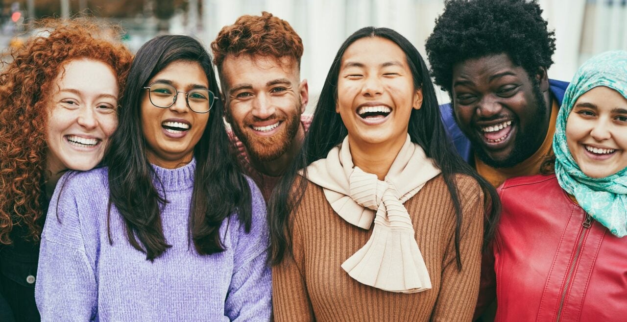 Young happy people having fun outdoor together - Focus on asian girl face