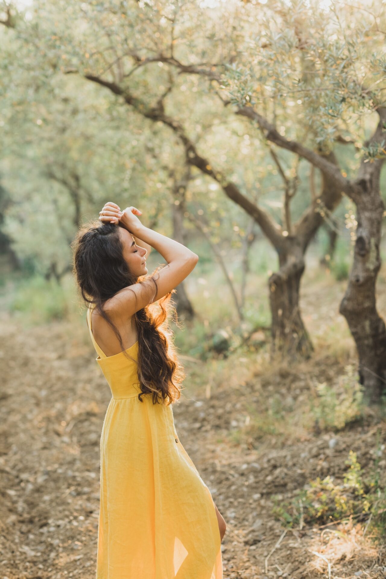 Closeup tender portrait of beautiful curly brunette woman in beautiful sun light. Natural beauty
